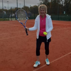 Judith poised with her tennis racket on a court