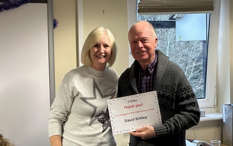 Smiling lady next to a smiling man who is holding a certificate