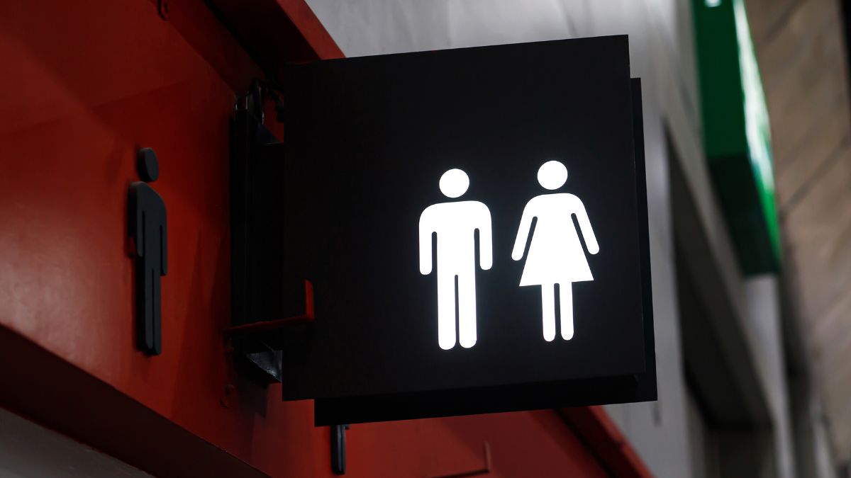 Sign outside a toilet showing the stick man and stick woman characters